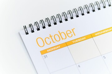 Obraz premium Closeup of a calendar opened on the October month page and placed on a white background