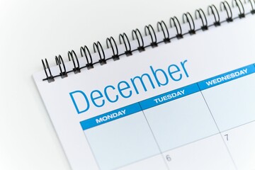 Closeup of a calendar opened on the December month page and placed on a white background