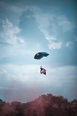 Lover of extreme sports skydiving with a parachute with a flag on his shoulder