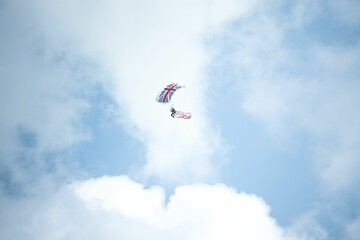 Lover of extreme sports skydiving with a parachute with the UK flag from the cloudy sky