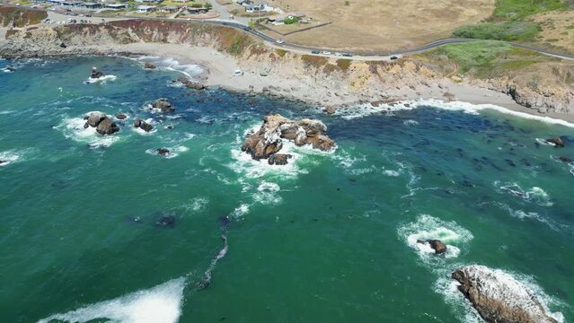 Beautiful drone footage of a calm sunny day at the sea surrounded by rocks