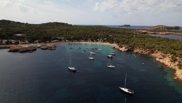 Sailing boats and tourists in the bay in Ibiza