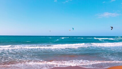 A group of people kite surfing at Alagadi Beach in Kyrenia, North Cyprus on sunny day with clear sky