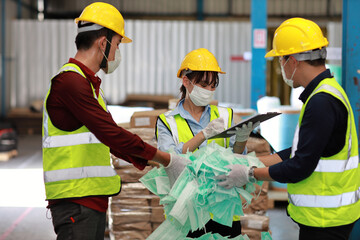 Group of asian technician engineer and businessman in protective uniform inspecting quality of mask and medical face mask production line in factory manufacturing industry and factory concept