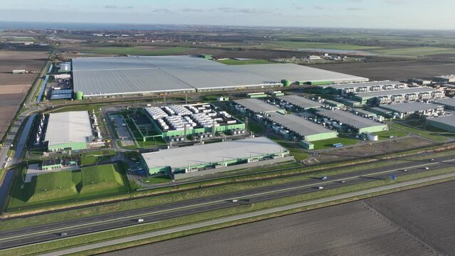 Explore the cutting-edge technology and futuristic infrastructure of a large-scale data center in the flat lands of the Netherlands through this captivating aerial drone video.