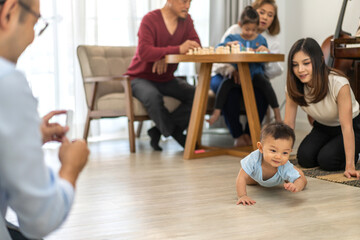 Portrait of enjoy happy love family asian mother playing and teaching help adorable little asian baby learning to crawling.Mom help first step with cute son beginnings development at home.Love family