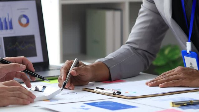 Sales are working together to summarize monthly sales to bring in a meeting with executives, female employees using smartphones to view sales data. Sales management concept.