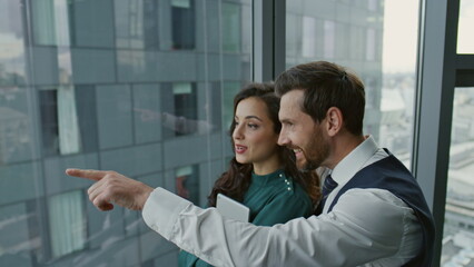 Business couple colleagues talking joyfully about work in office close up.