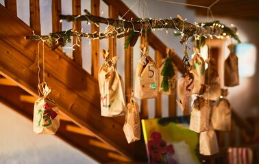 Homemade advent calendar with bags on a illuminated branch