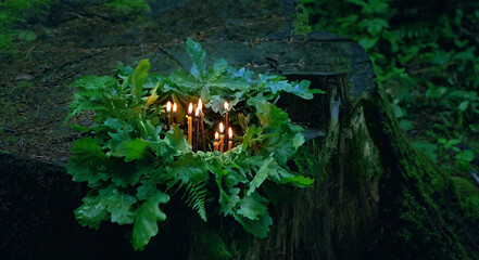 burning candles, oak and fern leaves on tree stump, dark forest background. Magic, wiccan spiritual practice, Witchcraft. Esoteric pagan Ritual. Summer Solstice Day, Midsummer, Litha sabbat. - obrazy, fototapety, plakaty