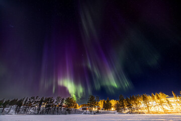 Purple, blue, white and green Northern lights (aurora borealis) 
above Ounasjärvi lake in Hetta,...