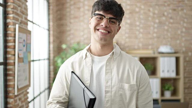 Young hispanic man business worker smiling confident holding binder at office