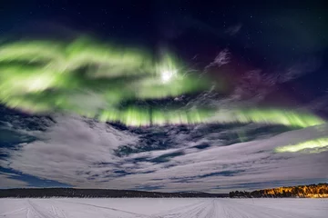 Fotobehang Circular green Northern lights (aurora borealis)  with moon above Ounasjärvi lake in Hetta, Lapland, Finland © Simon van Hemert