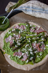 Pizza with green asparagus, peas and cheese on a rustic