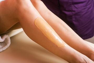 sugar paste on the skin of the leg, hair removal procedure with paste. cosmetic procedure. Depilation procedure