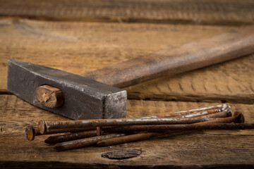 Vintage hammer with nails on wood background