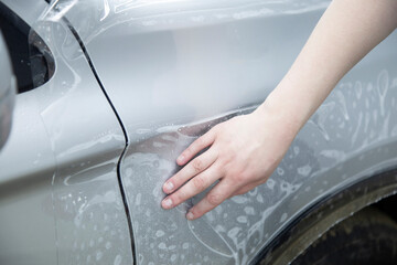 Process of pasting hood of car with protective vinyl film from gravel chips and scratches. Transparent protection for paint.