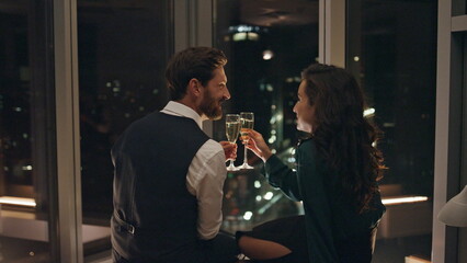 Attractive man flirting woman drinking champagne late evening. Couple relaxing.