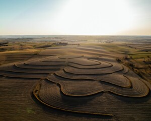 Fototapeta na wymiar Aerial view of a sunset sky over a textured farm countryside field