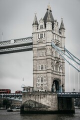 Fototapeta na wymiar Vertical shot of the scenic Tower Bridge in London with waterscape on a cloudy day