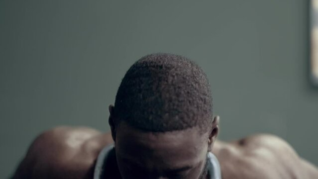 Intense shot of an African American man doing weighted Dips