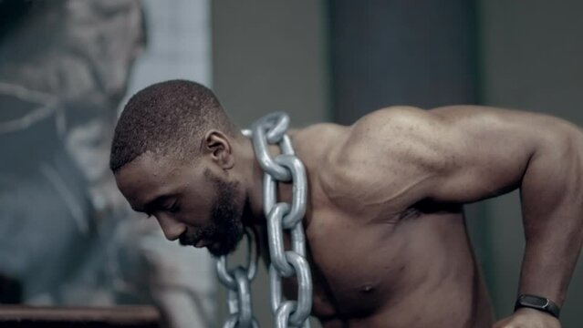 Fit African American man performs weighted dips