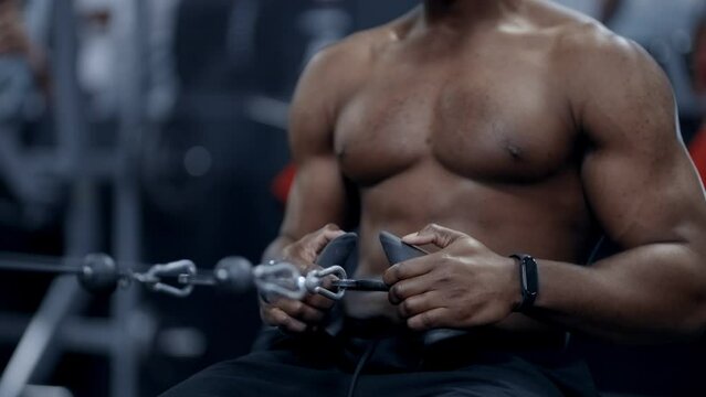Strong African American man doing seated cable rows