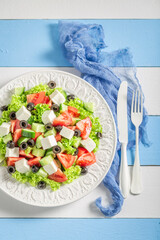 Delicious and homemade Greek salad with lettuce, tomatoes and onion.