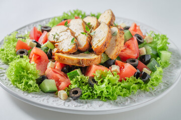 Delicious Caesar salad with tomatoes and olives and lettuce.