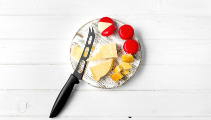 Italian cheese parmesan on plate with knife and other delicatessen. Delicious snack appetizer with protein