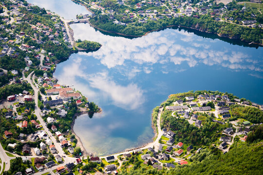 An aerial view capturing a village of Lofoten with the sky reflected on the calm waters below.