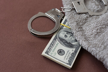 handcuffs, dollars, fingerprints, a gun with a silencer, drugs on a wooden background. arresting a criminal, drug trafficking.