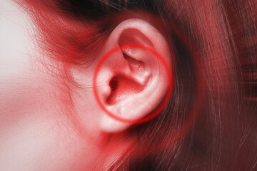 Close-up of female ear with red source of pain