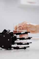 Robotic caregiver extending a hand with a glass of water to young woman