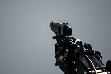 First person view of real robot's hand with handgun. Concept of AI takeover and technological...