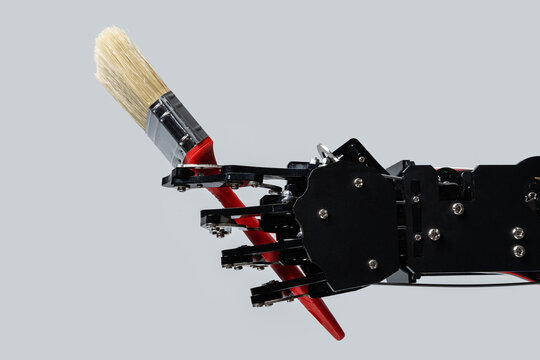 Real robotic hand with paintbrush. Concepts of Artificial intelligence development or job replacement by AI
