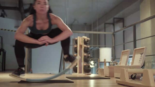Girl exercising on balance board in fitness studio..