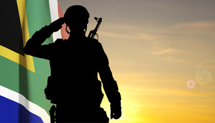Silhouette of a saluting soldier with South Africa flag against the sunset. EPS10 vector
