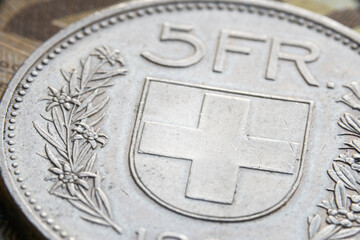 Coin of the swiss francs currency on banknote