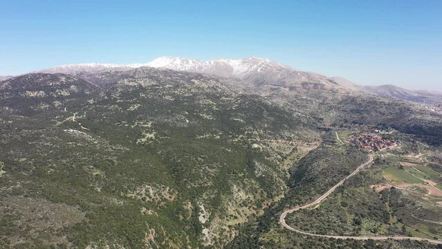 Aerial video on the north of the Golan Heights with the snow-covered Mount Hermon 