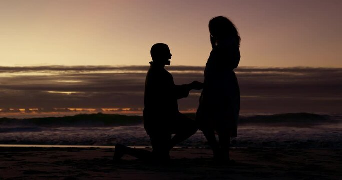 Love, silhouette and couple on a beach, engagement and relationship with happiness, vacation and support. Dark, man and woman on seaside holiday, proposal and asking for hand in marriage and romance