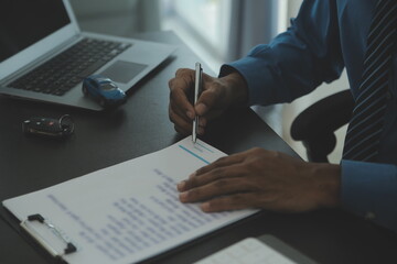 Man signing car insurance document or lease paper. Writing signature on contract or agreement....