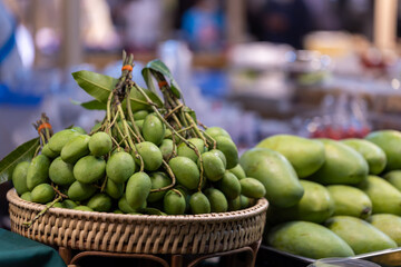 Group of raw green mangoes in basket for sale in the market