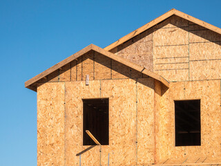 Two window openings on the upper story of a single-family suburban house under construction on a sunny morning in southwest Florida