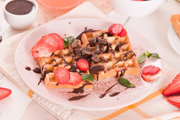 Waffles with strawberries and chocolate cream. - 607098527