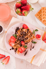 Waffles with strawberries and chocolate cream. - 607098541