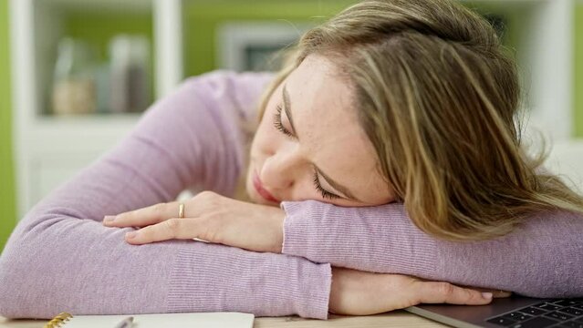 Young blonde woman sleeping on table at dinning room