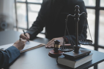 Justice and law concept.Male judge in a courtroom with the gavel, working with, computer and docking keyboard, eyeglasses, on table in morning light