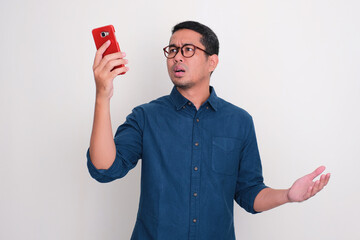 Adult Asian man searching for phone signal with confused expression