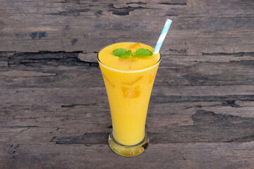 Mango juice fruit smoothies yogurt drink yellow healthy delicious taste in a glass slush for weight loss on wooden background.